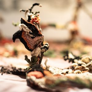 De la serie :De una vida a otra. Umbrales afectivos y 
materias sorprendentes .
2026
Detalles tela sublimada y bordada a mano, pelo humano 
y piel de iguana.